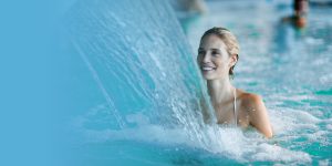 Une jeune femme épanouie dans le bain d'une cure thermale.